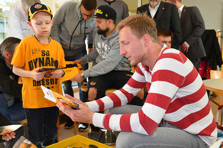 Dynamo-Kapitän Marco Hartmann
beschenkt den kleinen Lenny mit einem Dynamo-Buch.