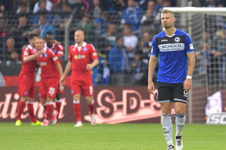 Arminias Florian Hartherz ist frustriert - im Hintergrund feiern die Duisburger ihren verdienten 4:0-Sieg.