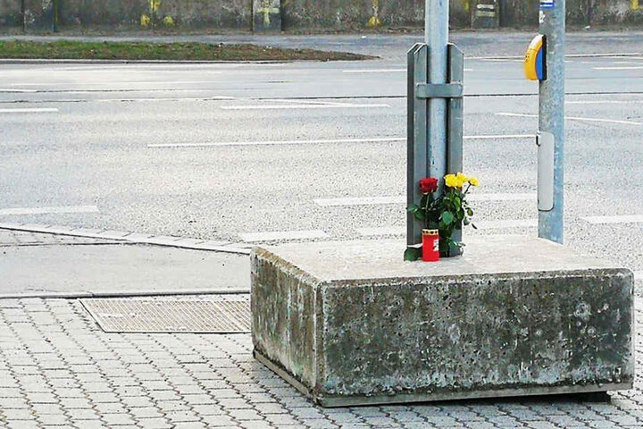 Rosen und eine Kerze erinnern an den tragischen Unfall.