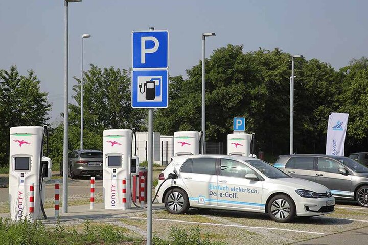 Schilder verweisen am Parkplatz hinter der Tankstelle auf die vier Superladesäulen.