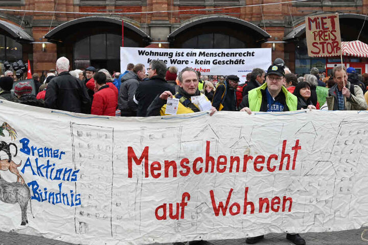 Zahlreiche Menschen demonstrieren vor dem Bahnhofsvorplatz mit Transparenten.
