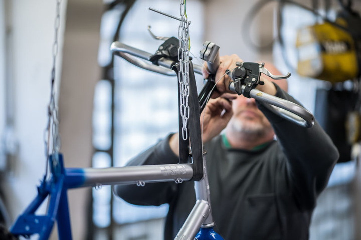 Der 58-jährige Häftling Uwe steht in der Fahrradwerkstatt der Abteilung für lebensältere Inhaftierte in der JVA Bielefeld-Senne und repariert ein Fahrrad.