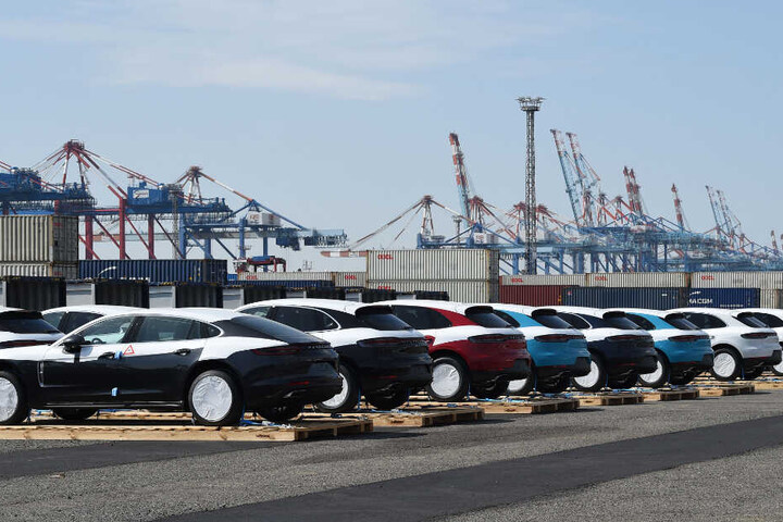 Porsche-Fahrzeuge stehen in Bremen vor ihrer Verladung in Containern auf Paletten. Die Autos werden mit dem Zug über die neue Seidenstrasse nach China gebracht.