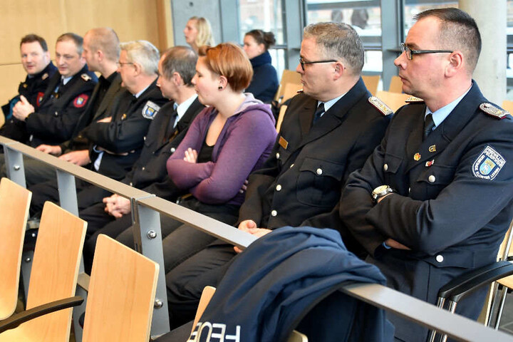 Feuerwehrleute warten im Amtsgericht auf den Prozessbeginn.