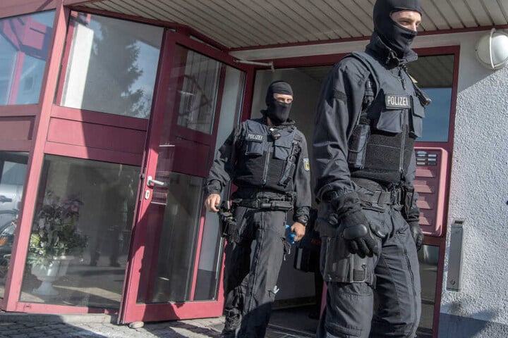 Vermummte Beamte der Bundespolizei kommen aus einem Bordell.