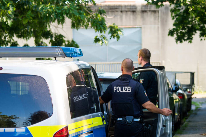 Polizisten stehen neben einem Polizeifahrzeug vor der Justizvollzugsanstalt Lübeck. Hier hat es am Montagnachmittag eine Geiselnahme gegeben.