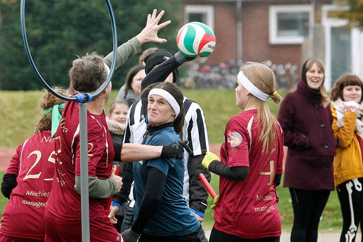 Spielerinnen und Spieler von Ruhr Phoenix (blau) und Münster Marauders (rot) kämpfen um den Ball.