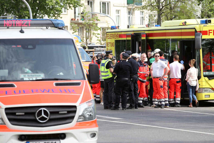Rettungskräfte und Polizisten stehen vor einem Einsatzfahrzeug zusammen. Im Schanzenviertel war in einem sechsgeschossigem Haus ein Feuer ausgebrochen.