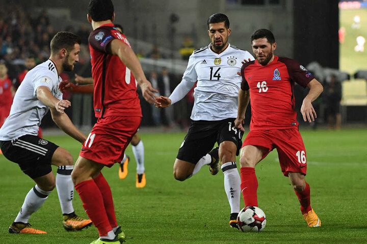 Shkodran Mustafi (l) und Emre Can von Deutschland gegen Javid Hüseynov von Aserbaidschan.