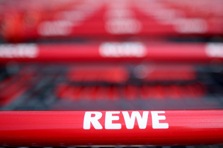 Einkaufswagen stehen vor einem Rewe Supermarkt. (Symbolbild)