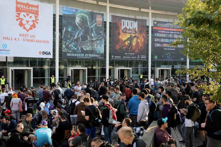 Messebesucher warten am Mittwoch vor einer Messehalle der Gamescom auf den Einlass.
