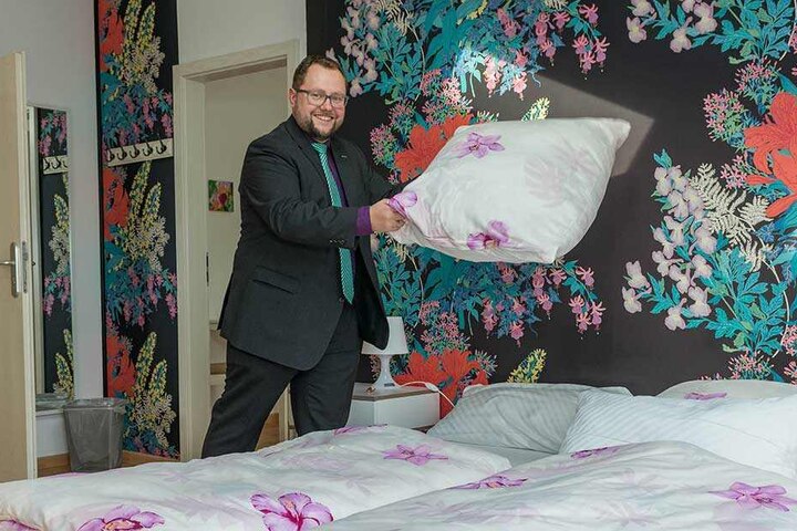 Frisch bezogen! Andreas Führlich schüttelt die Kissen im Elternzimmer auf.