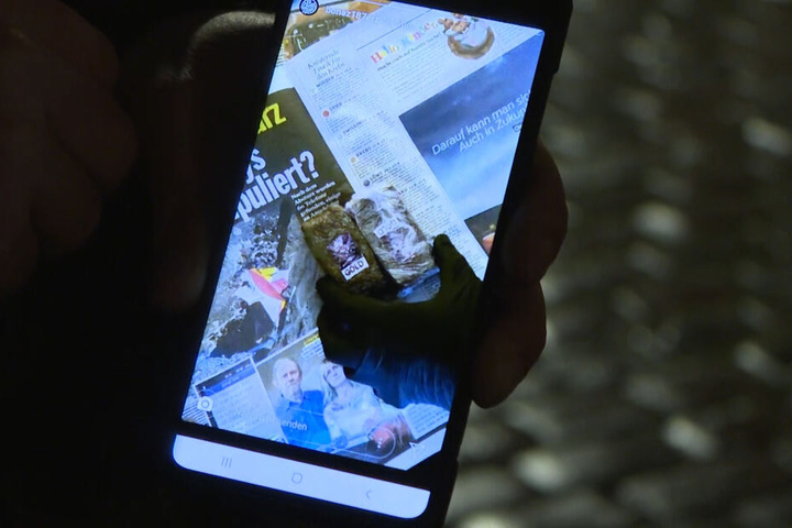 Ein Beamter spielt auf einem Handy das Instagram-Video ab.