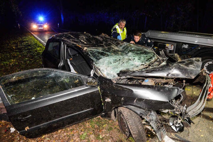 Polizisten begutachten den völlig zerstörten Fiat des Opfers.