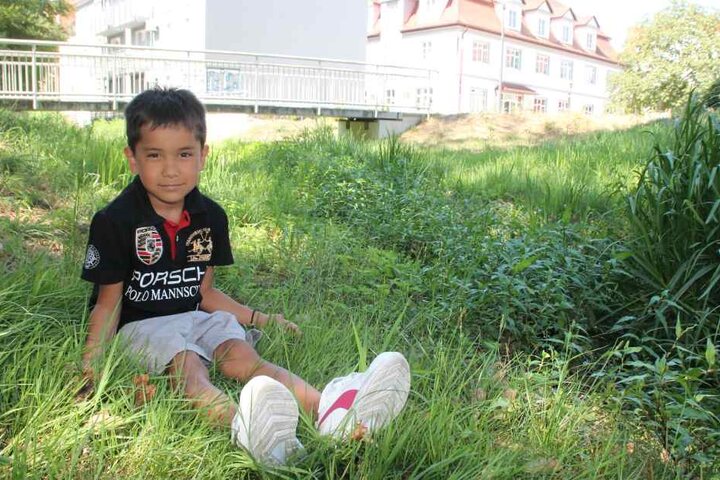 Hier fließt sonst Wasser: Felipe (6) sitzt im ausgetrockneten "Elsterfließ" in Hoyerswerda.