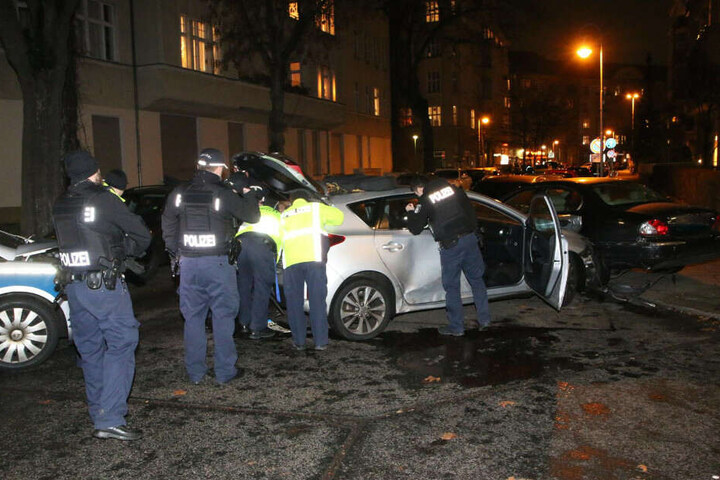 Polizisten untersuchen das Fluchtfahrzeug.