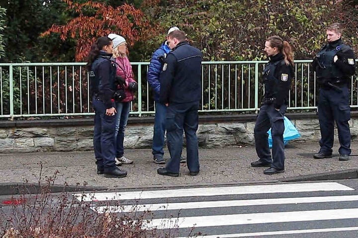 Polizisten befragen mögliche Augenzeugen des Unfalls.