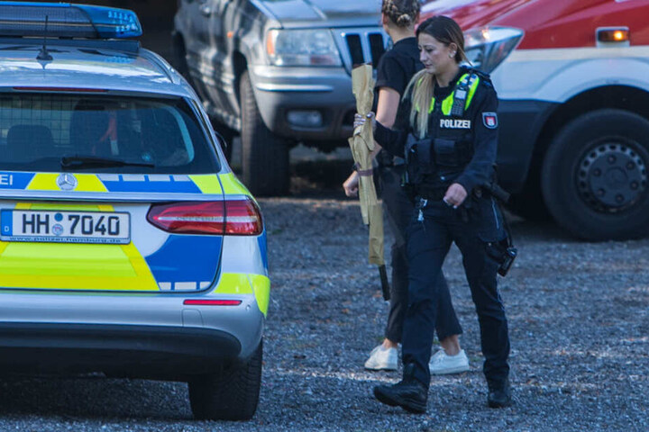 Eine Polizisten stellt das Gewehr des Mannes sicher.