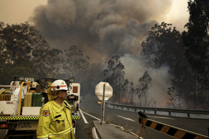 Eine Crew des Nationalparks zieht sich zu einer Straßensperre zurück, während das Hillville-Feuer entlang des Bullocky Way brennt.