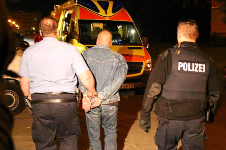 Der Mann wird in Handschellen von zwei Polizisten abgeführt.