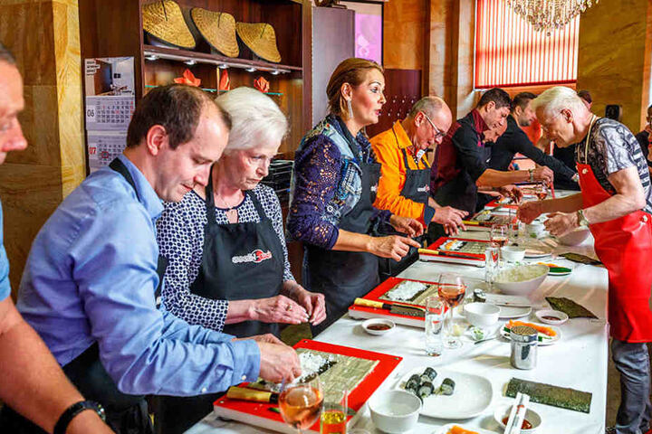 Wolle Förster (62, r.) zeigt Helena Fürst (43), wie man eine Sushi-Rolle
füllt.