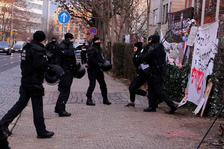 Eine Aktivistin wird von Polizisten abgeführt.