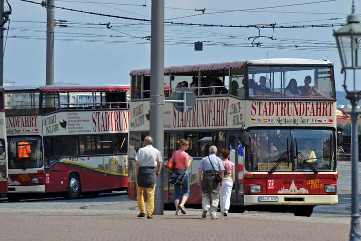 Stadtrundfahrt-Busse warten auf dem Dresdner Theaterplatz auf Touristen.