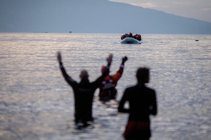 Flüchtlinge kommen in einem Schlauchboot aus der Türkei auf der griechischen Insel Lesbos in der Nähe der Hafenstadt Mitilini (Griechenland) an und werden von Helfern erwartet.
