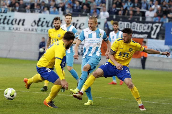Mittelfeldspieler Dennis Grote von Lok-Spielern umzingelt.