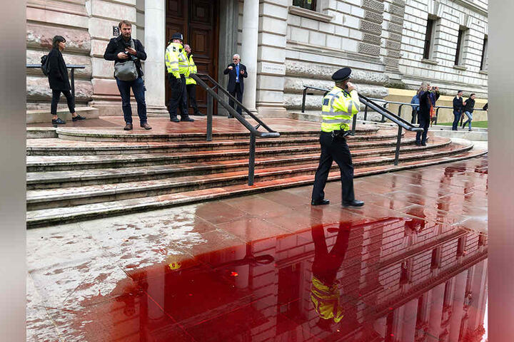 Ein Polizist telefoniert vor dem Finanzministerium während des Protests der Gruppe "Extinction Rebellion".