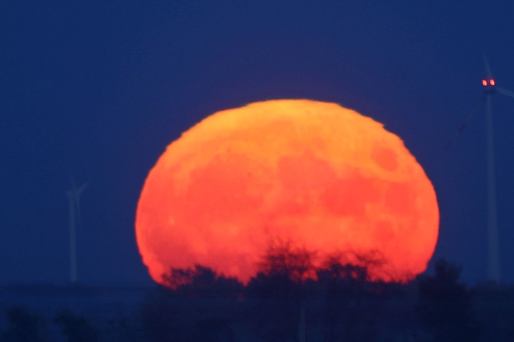 Bei Waldenburg (Landkreis Zwickau) geht der Mond als roter Feuerball auf.