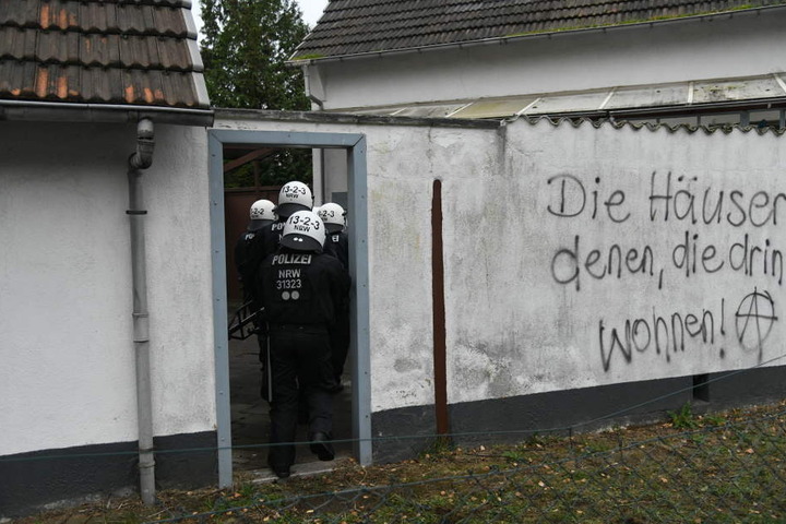 Polizisten gehen in den Hof eines Hauses, das von Braunkohlegegnern besetzt worden war.
