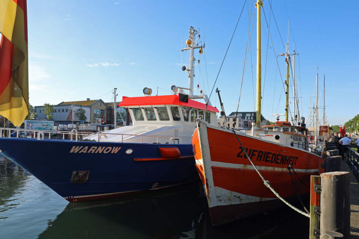 Die "MS Zufriedenheit" liegt im Hafen, vor ihr liegt ein Boot der Wasserschutzpolizei.