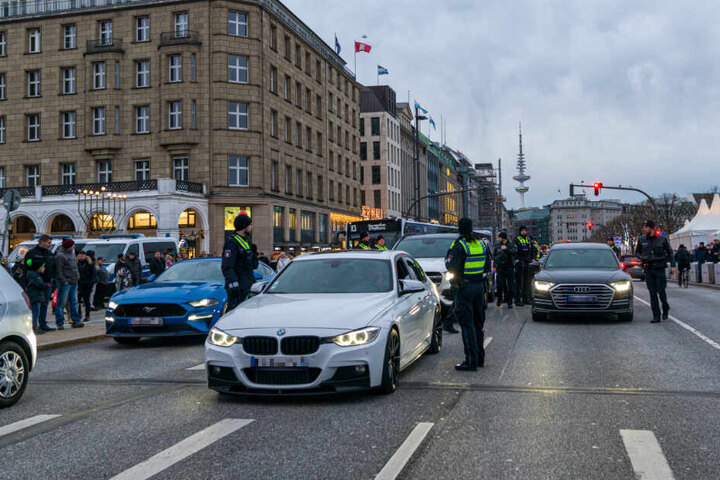Polizisten kontrollieren die Luxus-Autos.