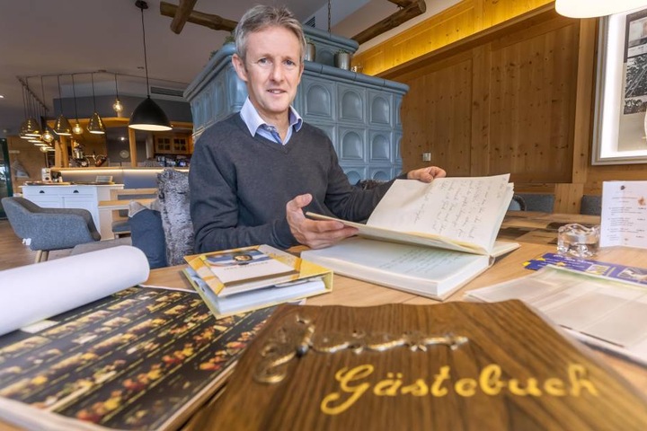 Jens Weissflog blättert in einem Gaestebuch