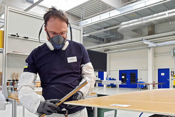Mitarbeiter Martin Ullrich (31) säubert die Kanten der Frachtraumverkleidung. Im Fachjargon heißt das entgraten.