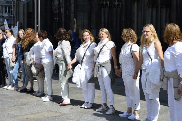 Unterstützer der Protestbewegung "Maria 2.0" bilden vor dem Kölner Dom eine Menschenkette.
