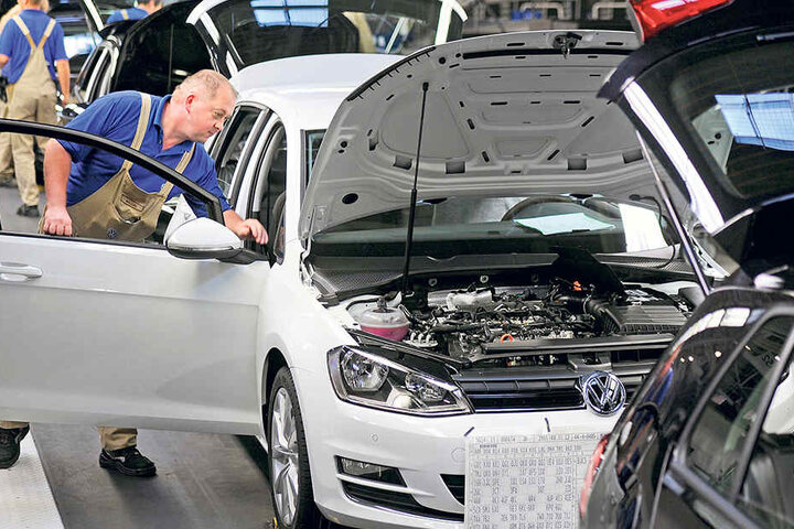 Ein Mitarbeiter von Volkswagen Sachsenkontrolliert einen Golf VII in der Endmontage.