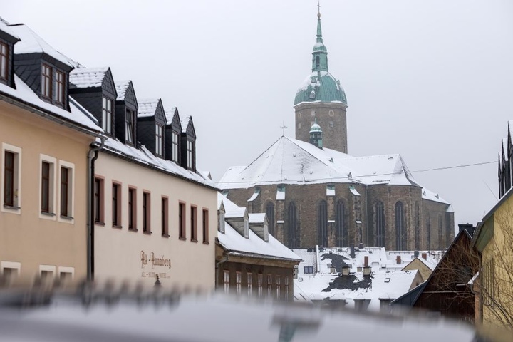 Im Erzgebirge hat es einige Zentimeter Neuschnee gegeben. Die Dächer um die St. Annen Kirche in Annaberg-Buchholz sind verschneit.