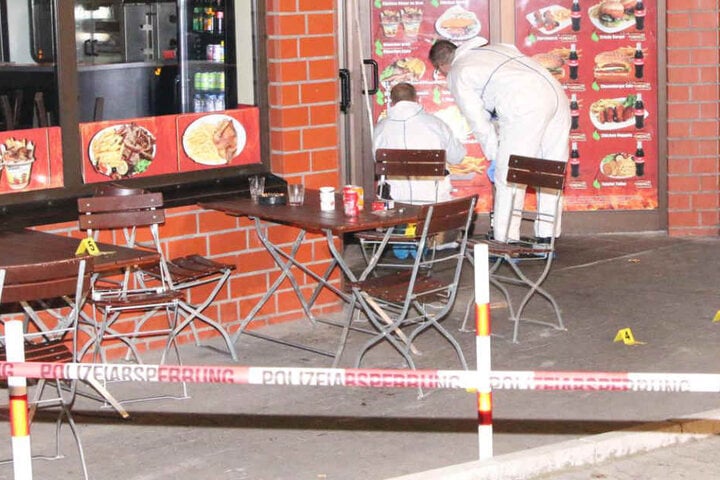 Polizisten markierten die Einschusslöcher in der mit Werbung beklebten Tür.