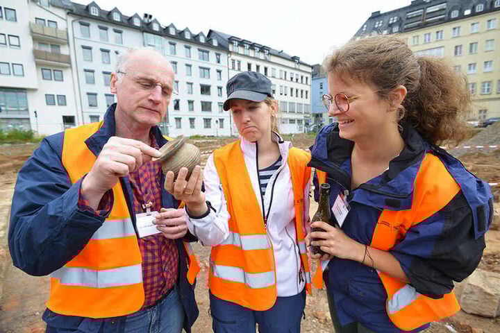 Dr. Christoph Heiermann (59, v.l.), Linda Burghardt (30) und Lisa van Bömmel-Wegmann (28) vom Landesamt für Archäologie mit einem Tontöpfchen aus dem 14. Jahrhundert.