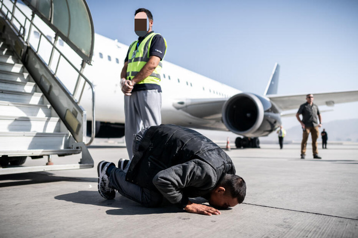 Nach der Landung in Kabul küsst dieser Afghane den Boden seines Heimatlandes.