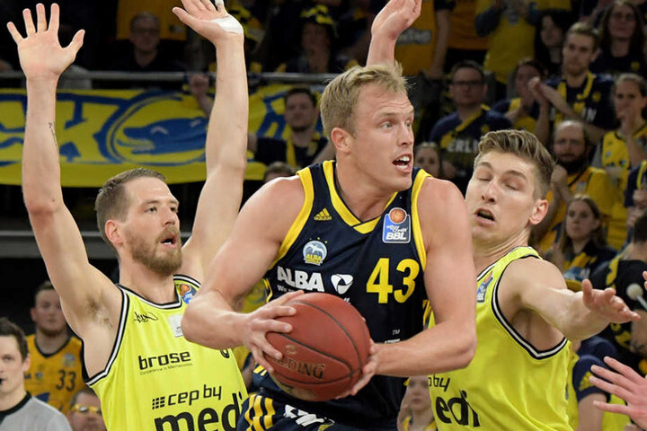 Bayreuths Nate Linhart (l) und Andreas Seiferth kämpfen mit Luke Sikma (M) von Alba Berlin um den Ball.