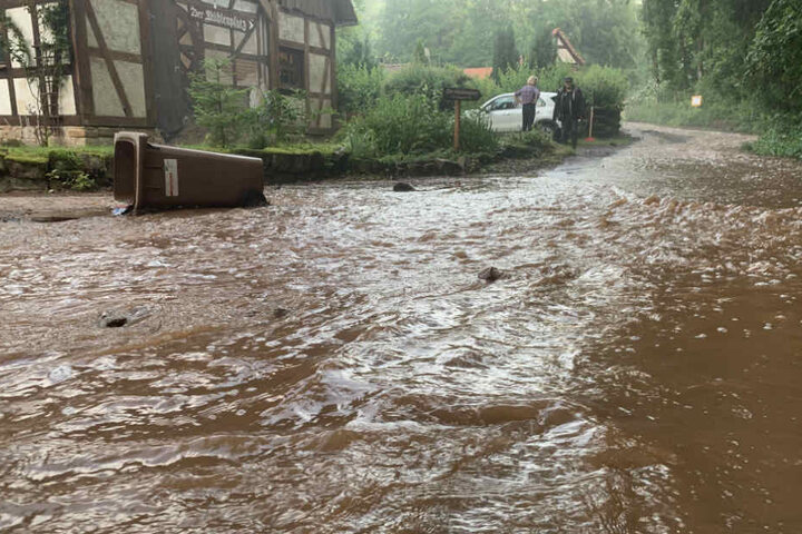 Eine Straße in Gieselwerder ist von Schlammwasser überspült.