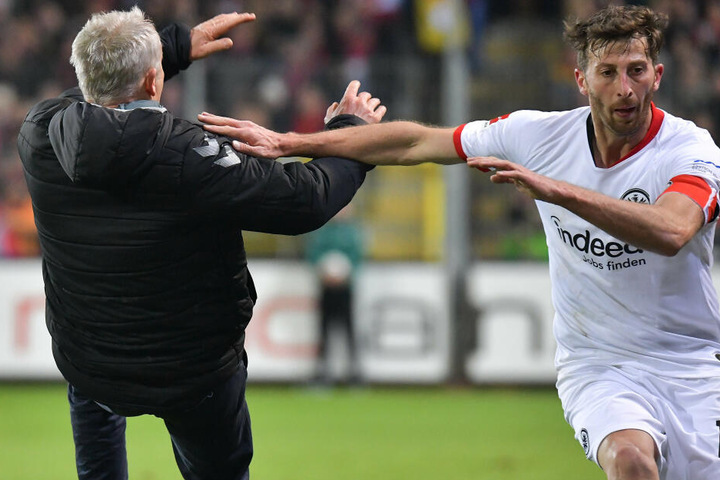 Trainer Christian Streich (SC Freiburg) wird von David Abraham (Eintracht Frankfurt) umgerannt.