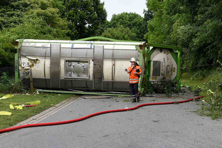 Ein Feuerwehrmann steht vor zwei verunglückten Güter-Waggons.
