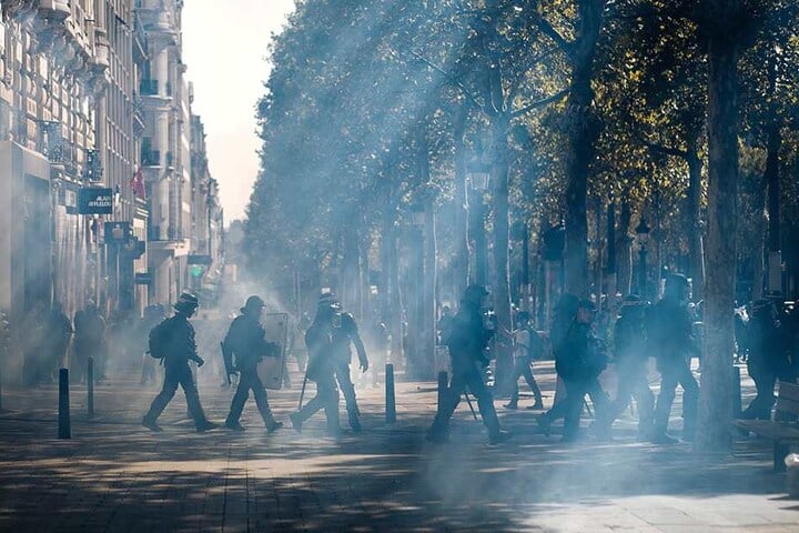 Französische Bereitschaftspolizei geht während der "Gelbwesten"-Demonstration durch eine Tränengaswolke auf den Champs-Élysées.