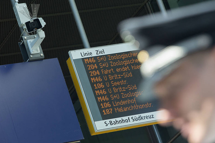 Ein Bundespolizist steht vor einer Überwachungskamera im Bahnhof Südkreuz.