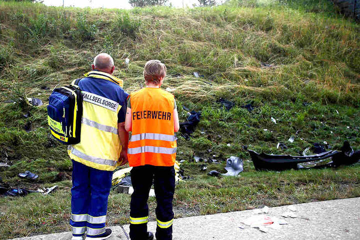 Ein Seelsorger und ein Mitglied der Feuerwehr stehen an der Unfallstelle.