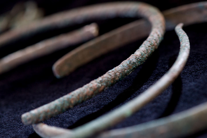 Drei unterschiedlich große Halsringe aus einem bronzezeitlichen Hortfund werden während archäologischer Grabungsarbeiten bei Obhausen gezeigt.